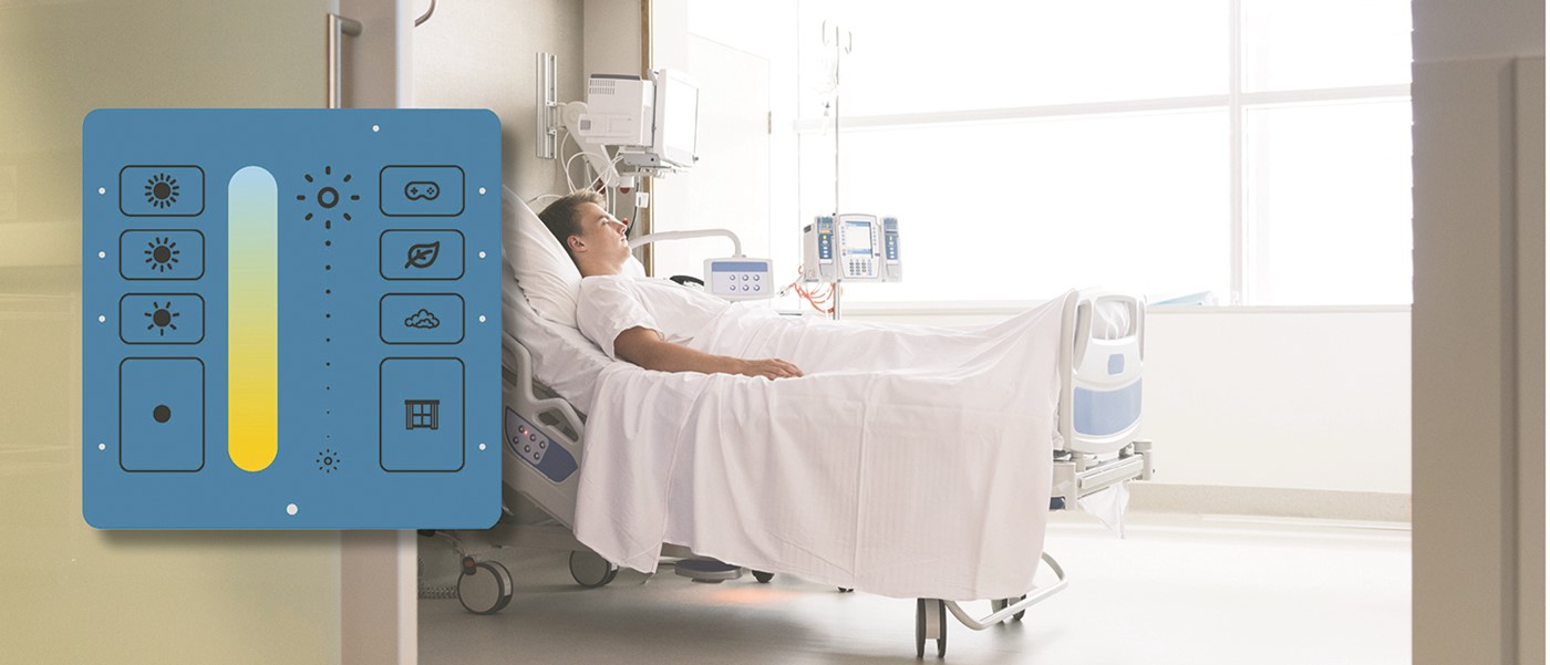 Patient på sengestue med specialdesignet blåt ILLUSTRIS panel fra Helvar i forgrunden