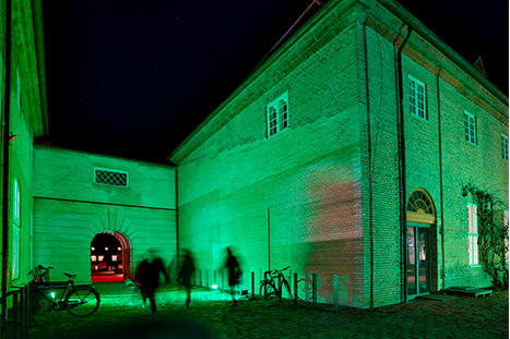Kuglegården med grønt lys på facaden
